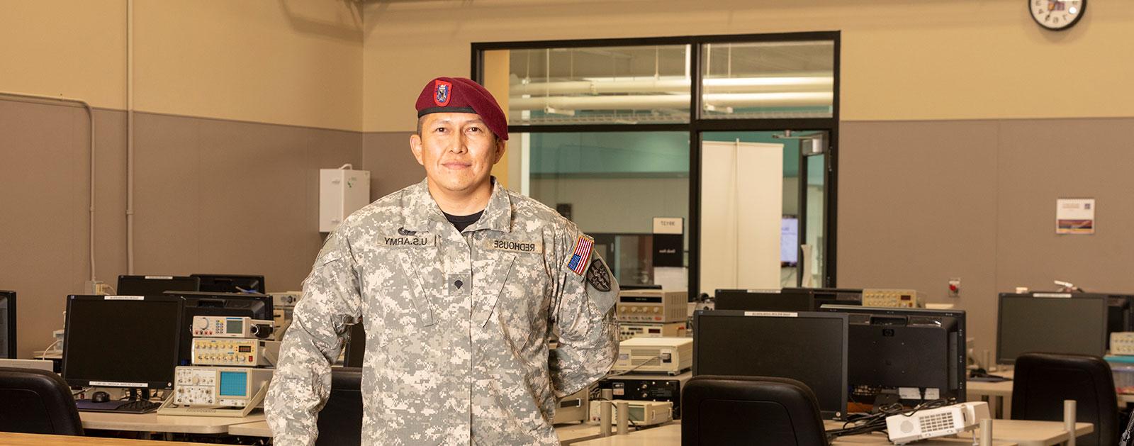 San Juan College Veteran Student with uniform on in the computer lab.